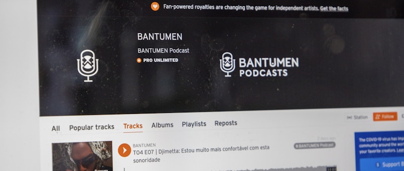 A computer screen displaying a website of an audio streaming service. The website showcases a podcast called BANTUMEN with the description 'Pro Unlimited.' There is a navigation bar with options including Home, Stream, Library, and more. A music wave graphic is visible below, along with a play button, social media interaction options such as re-post, share, and add to playlists. A banner at the top talks about fan-powered royalties, and there is a COVID-19 information widget to the side.